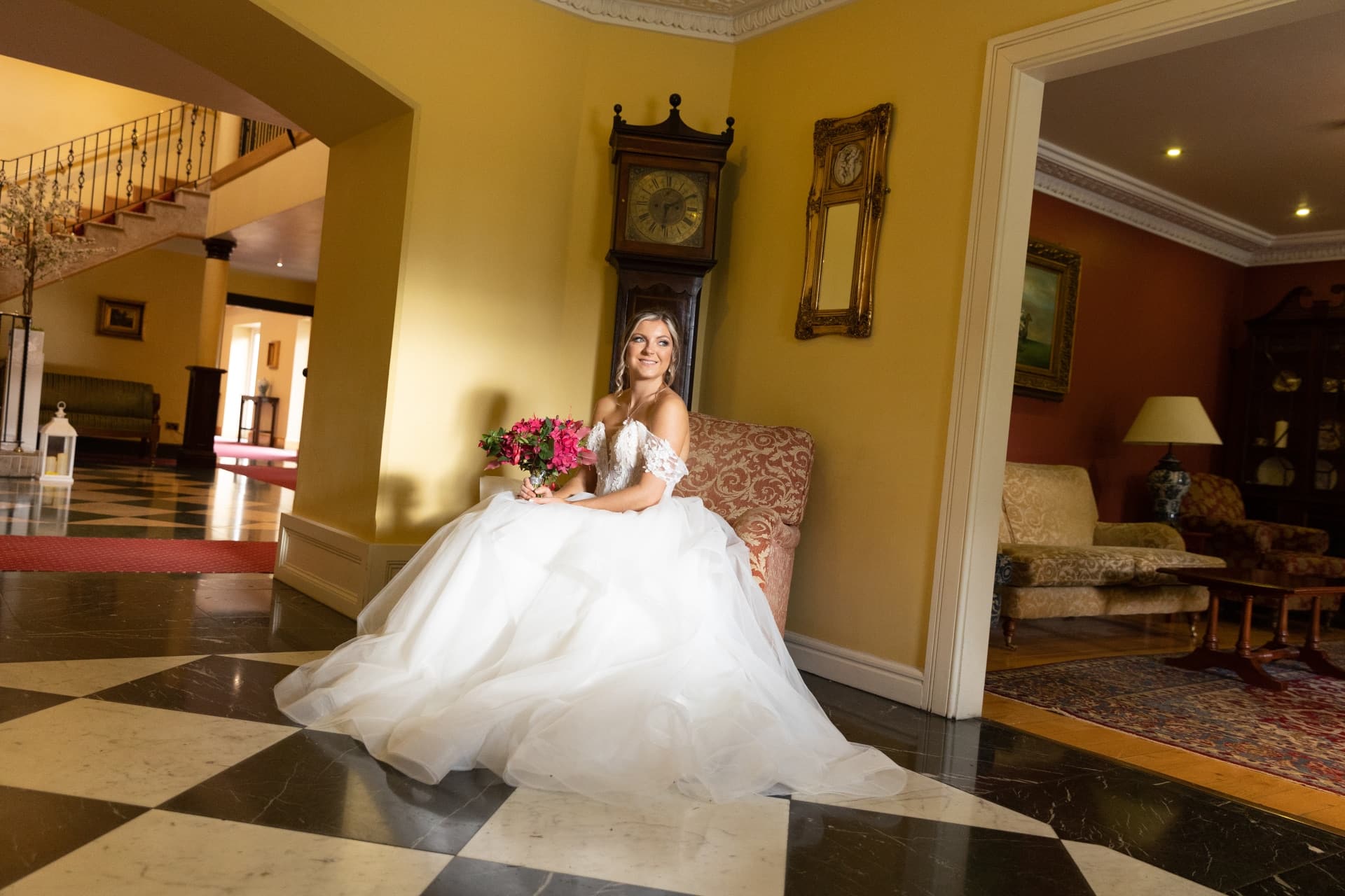 Picture of bride sitting down holding flowers smiling